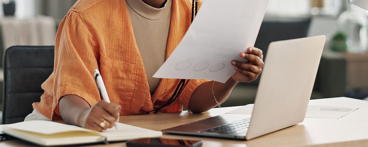 woman-at-desk-with-computer-writing-notes